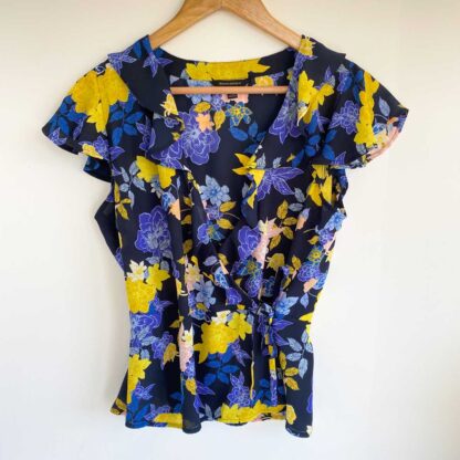 Full front view of a preloved Banana Republic floral wrap blouse in a blue, yellow and pink print with tie detail at waist