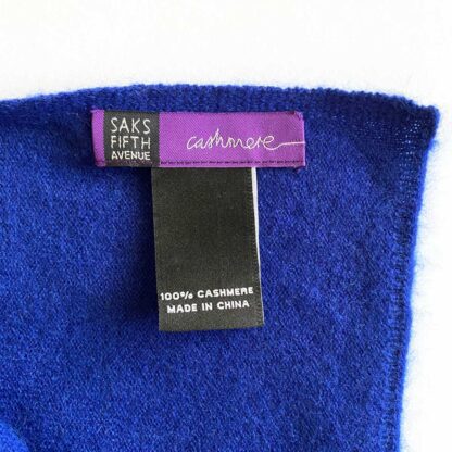 View of a bright blue Sakes pure cashmere wrap with a Saks Fifth Avenue label and material tag