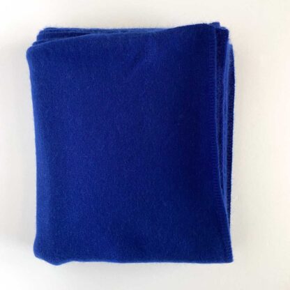 Overhead view of a Saks pure cashmere wrap in a bright blue folded into a square.
