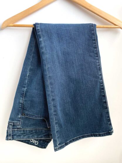 A pair of vintage Gap women's jeans in the Long and Lean fit, folded in half and folded over a wooden hangar.