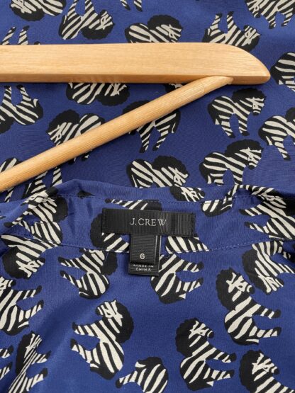 view of the neckline and the brand tag in a J.Crew silk blouse in a zebra print